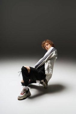 Genç kıvırcık saçlı bir adam atletik dansını canlı bir stüdyoda sergiliyor..