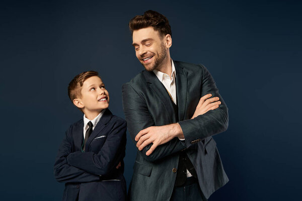 Father and son share a joyful moment on Fathers Day, dressed elegantly and smiling at each other.