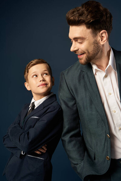 A proud father smiles at his admiring son, celebrating family bonds this Fathers Day.