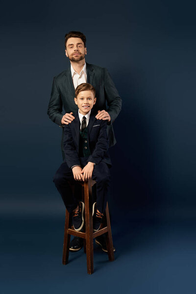 Father and son share a joyful moment, dressed elegantly, embracing the spirit of togetherness.