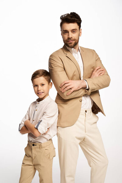 A stylish dad and son duo proudly showcase their matching outfits while celebrating Fathers Day.
