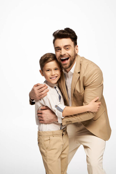 A father and son share a heartfelt hug, radiating happiness during their Fathers Day celebration.