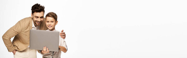 Father and son share a delightful moment while video chatting together, celebrating their bond.