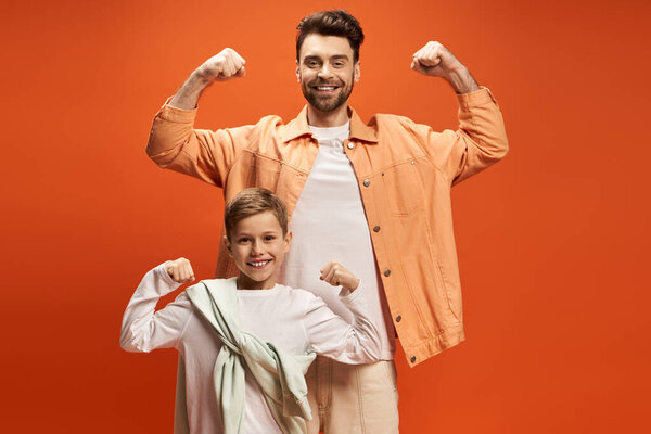A father and son share smiles and flex muscles at a festive celebration.