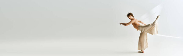 Young man with curly hair showcases his dance skills in a spacious studio setting, banner