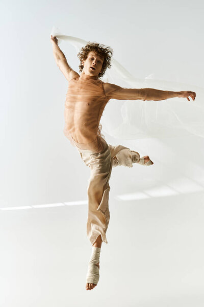 A young man with curly hair performs an expressive dance in a studio setting, energy radiating.
