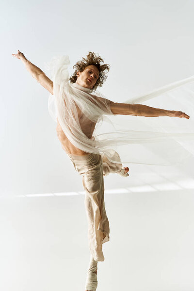 Young man with curly hair dances gracefully in a studio, showcasing athleticism and creativity.