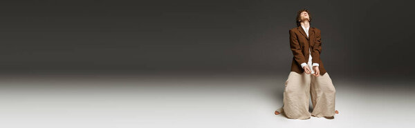 Молодой танцор с вьющимися волосами демонстрирует свои спортивные навыки в студии, погруженной в ритм, баннер