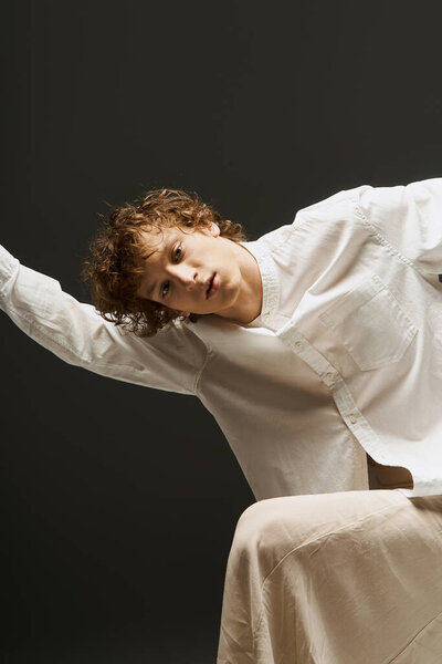 Curly-haired dancer gracefully expresses creativity in a modern studio.