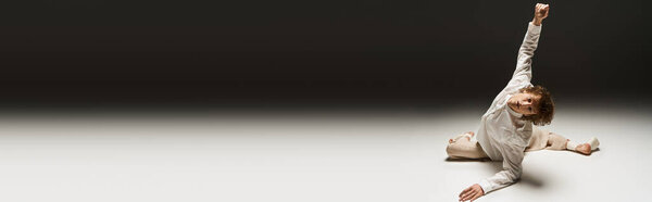 A young man with curly hair expresses his passion for dance in a modern studio setting, banner