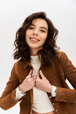 Genç bir kadın şık inek desenli pantolonunu ve şık bluzunu sergiliyor. Stüdyoya güven saçıyor..