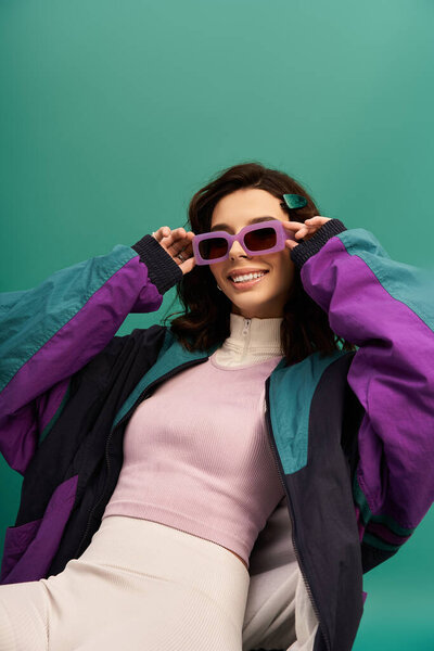 Young woman showcases her bold fashion sense with a sporty look in a studio setting.