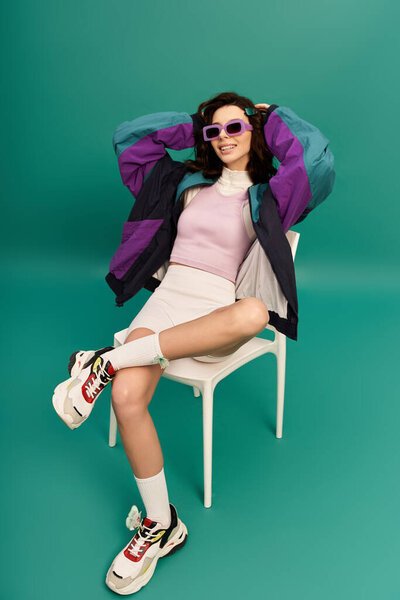 A young woman poses confidently in a fashionable sporty outfit, exuding style and attitude.