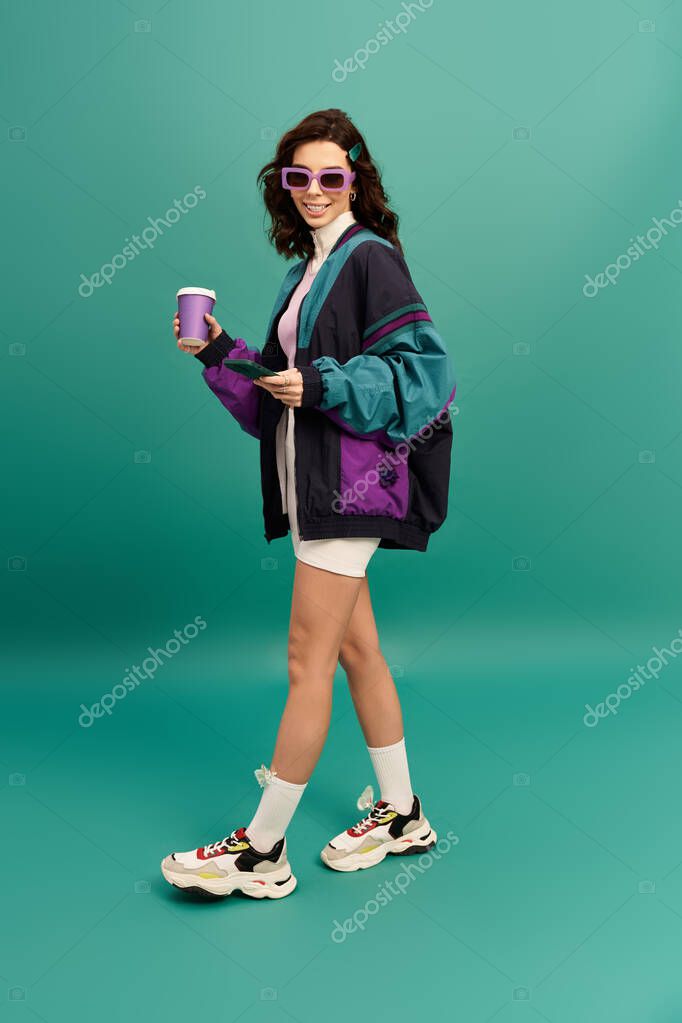 Sporty young woman in a trendy outfit enjoys a vibrant studio setting, showcasing her style.