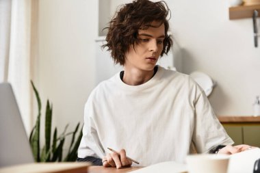 Genç bir adam çalışmalarına odaklanır, rahat kıyafetler giyer, parlak ve evine davet edilir..