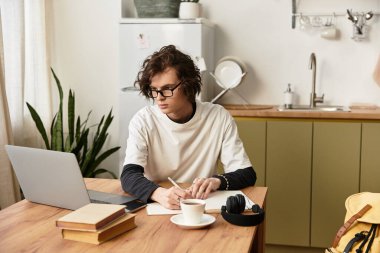 Rahat bir evde, rahat giyimli genç bir adam yaratıcı ve verimli çalışır..