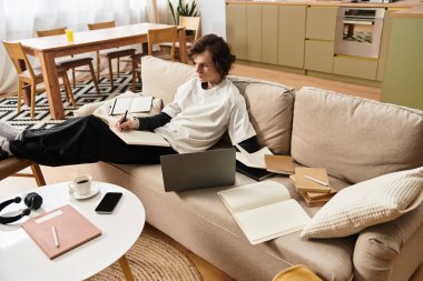 Genç bir adam rahat bir kanepede dinleniyor, evde kişisel projeler yazıyor ve çalışıyor..