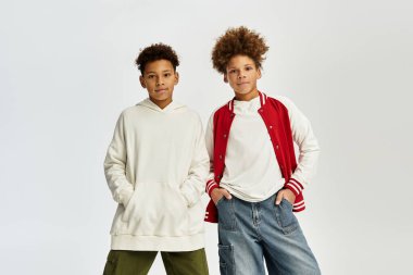 İki sevimli çocuk, modaya uygun kıyafetler giyip, mutluluk saçarak arkadaşlıklarını sergiliyorlar..