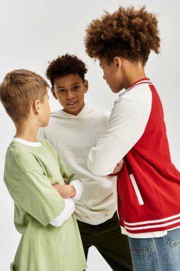Three little boys in trendy, colorful outfits enjoy a moment of friendship and camaraderie.