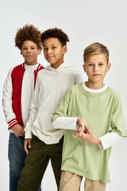 Adorable little boys dressed in stylish vibrant outfits enjoy a moment of friendship and fun.