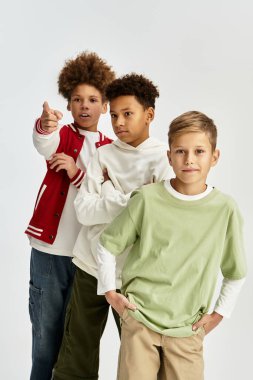 Three adorable boys express their friendship while showcasing unique, vibrant fashion styles.