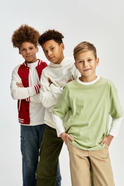 Three little boys dressed in colorful outfits showcase their friendship and unique styles.
