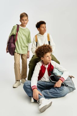 Şık giyinmiş üç sevimli erkek arkadaş ve neşe dolu bir anı paylaşıyorlar..