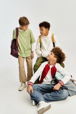 Three cheerful boys in colorful outfits share laughs as they prepare for fun together.
