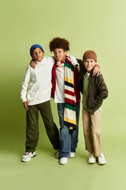Three stylish boys stand close together, highlighting their strong bond and playful spirit.