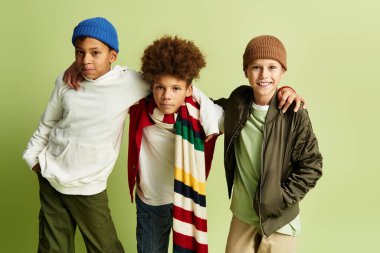 Three adorable boys wear stylish outfits while sharing a fun moment, highlighting their friendship.
