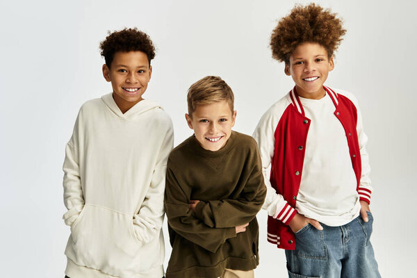 Три маленьких мальчика излучают счастье в модной одежде, празднуя их дружбу вместе.