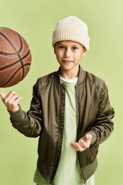 Yakışıklı bir çocuk, şık bir kıyafet giymiş, parmağında basketbol topu döndürüyor..