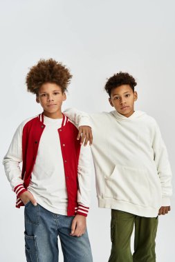 Canlı kıyafetler giymiş iki sevimli çocuk bir arkadaşlık ve stil anını paylaşıyor..