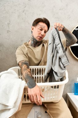 Yakışıklı genç adam evinde rahat vakit geçirmeyi seviyor. Çamaşırları şakacı bir tavırla katlıyor..