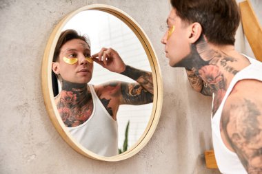 Dövmeli genç bir adam göz bantları altında rahat bir evde yaşıyor..