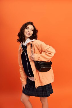 Genç bir kadın, kendine has tarzını canlı bir stüdyoda geçen şık bir etek ve ceketle ifade ediyor..