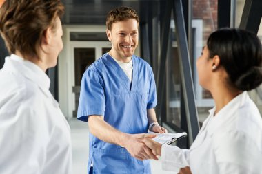 Three doctors collaborate in a modern hospital, sharing knowledge and expertise in medicine.