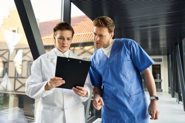 Two healthcare professionals reviewing results together in a modern medical facility.