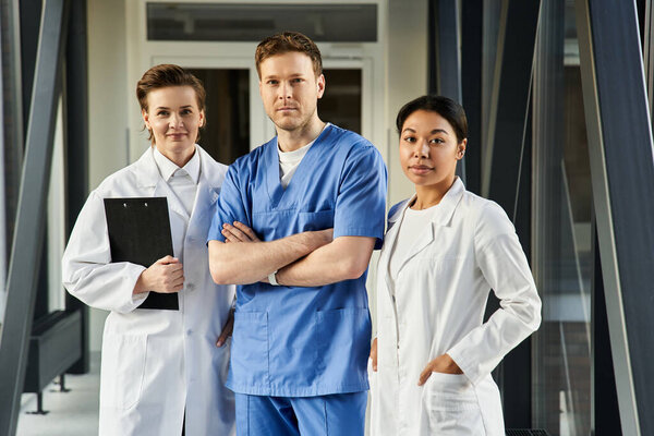 Three doctors, a black woman and two others, work together in a contemporary hospital setting.