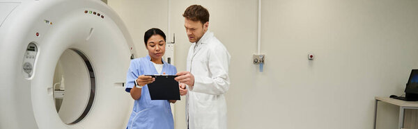 Two doctors examine MRI results while discussing patient care in a modern medical facility, banner