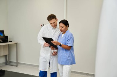 Two doctors examine MRI results together, showcasing teamwork in a modern healthcare facility.