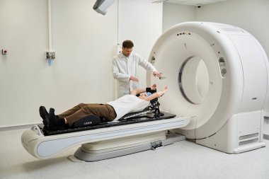 A skilled doctor in a white coat supports a female patient undergoing an MRI at a modern hospital.