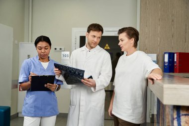 A caring doctor and nurse help a female patient after her MRI scan at the hospital.