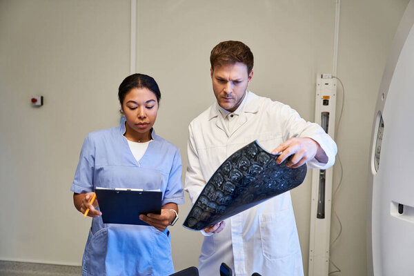 Two medical experts examine an MRI scan in a contemporary hospital setting.