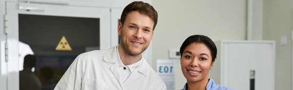 Two multicultural doctors work together in a modern hospital, banner