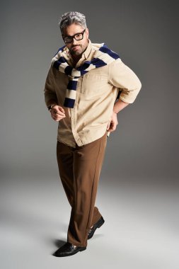 Gözlüklü şık bir adam şık bir kıyafetle kasıla kasıla yürür, modaya uygun bir hava yayar..