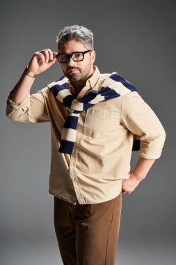 Yakışıklı bir adam zarif bir kıyafet içinde, stüdyoda modern bir cazibe yayıyor..