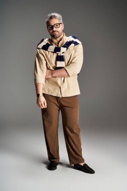 İyi giyimli bir adam gözlük takar ve şık bir kıyafet giyer..