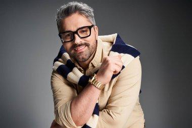 Yakışıklı bir adam şık bir kıyafetle şık bir stüdyo arka planında gözlüklü şık bir poz verir..