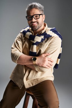 Kendine güvenen beyefendi şık bir kıyafet içinde modern bir stüdyoda moda trendlerini ön plana çıkarıyor..